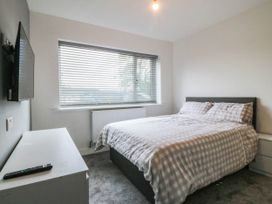 A bedroom with a bed and a television at Angorfa in Pentraeth
