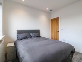 A bedroom with a bed and bedside table at Angorfa in Pentraeth