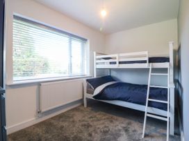 A bedroom with a bunk bed and a window at Angorfa in Pentraeth