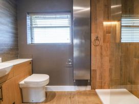 A bathroom with a sink, toilet, and shower at Angorfa in Pentraeth