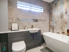 A bathroom with a sink, toilet, and bathtub at Angorfa in Pentraeth