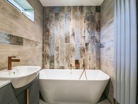 A bathroom with a bathtub and sink at Angorfa in Pentraeth