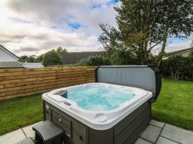 A hot tub with steps in a garden at Angorfa in Pentraeth