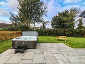 A garden with a hot tub and patio at Angorfa in Pentraeth