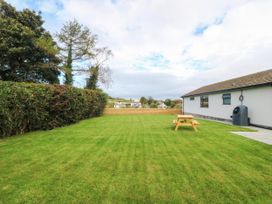 A garden with a table and water butt at Angorfa in Pentraeth