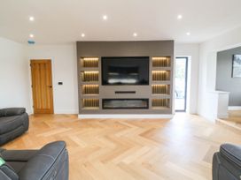 A living room with a television and fireplace at Angorfa in Pentraeth