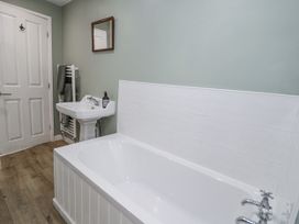 A bathroom with a bathtub, sink, and towel radiator at Haulfryn in Dolwyddelan