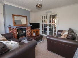 A living room with a fireplace and television at Forget Me Not Cottage in Hull