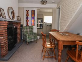 A living room with a fireplace and a dining table at Forget Me Not Cottage in Hull