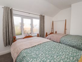 A bedroom with two beds and curtains at Forget Me Not Cottage in Hull