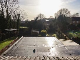 A view of a garden with roofs and trees at Forget Me Not Cottage in Hull