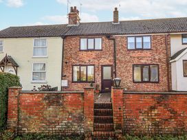 A brick house with steps and fence at Forget Me Not Cottage in Roos