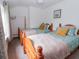 A bedroom with two beds and a closet rod at Forget Me Not Cottage Roos