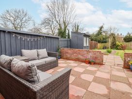 A garden with a sofa and a shed at Forget Me Not Cottage in Roos