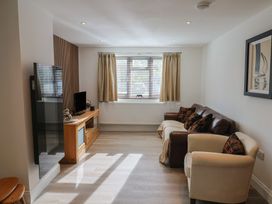 A living room with a sofa and television at Arum in Portland Bill