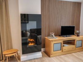 A living room with a fireplace and television at Arum in Portland Bill