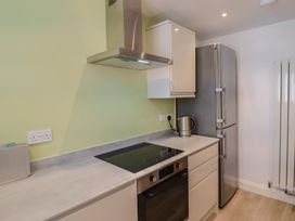 A kitchen with a refrigerator and electric stove at Arum in Portland Bill