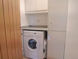 A utility room with a washing machine and cabinets at Arum in Portland Bill