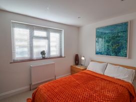 A bedroom with a bed and decorative painting at Arum in Portland Bill