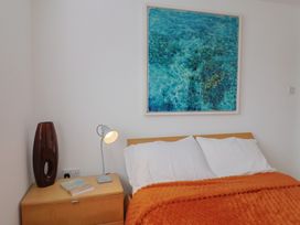 A bedroom with a bed and lamp at Arum Portland Bill