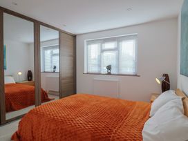 A bedroom with a bed and a mirror at Arum Portland Bill