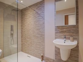 A bathroom with a shower, toilet, and sink at Arum in Portland Bill