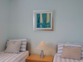 A bedroom with twin beds and a lamp at Arum in Portland Bill