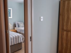 A bedroom with two beds and a bedside table at Arum in Portland Bill