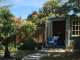A garden with a shed and chair at Evergreen in Broadway
