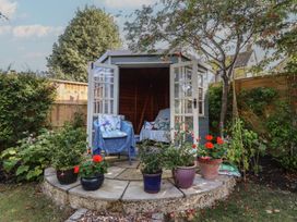 A garden shed surrounded by plants and seating at Evergreen in Broadway