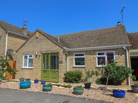 A house with a green front door and garden at Evergreen in Broadway