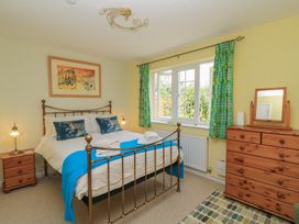 A bedroom with a bed and wooden furniture at Evergreen in Broadway