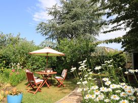 A garden with a table and chairs under an umbrella at Evergreen in Broadway