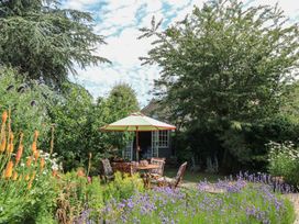 A garden with a table and chairs under an umbrella at Evergreen in Broadway