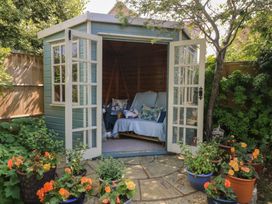 A garden shed with seating and flowers at Evergreen in Broadway