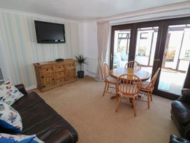 A living room with a dining table and television at Goetra