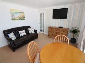 A living room with a sofa, table, chairs, and television at Goetra