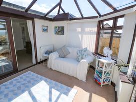 A conservatory with a sofa and side table at Goetra