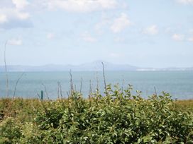 A view of water and mountains with bushes in the foreground at Goetra