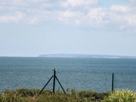 View of the ocean and distant land with a fence at Goetra