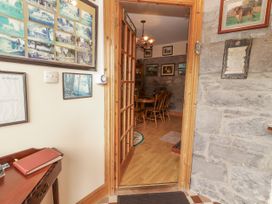 An entrance hall with a table and framed pictures at Coole Gate Lodge in Gort, County Galway