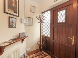 A hallway with a coat rack and a door at Coole Gate Lodge, Gort, County Galway