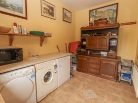 A laundry room with appliances and storage at Coole Gate Lodge in Gort, County Galway
