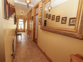 A hallway with a mirror and photographs at Coole Gate Lodge, Gort, County Galway