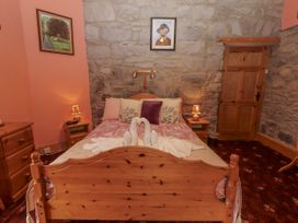 A bedroom with a double bed and nightstand at Coole Gate Lodge in Gort, County Galway
