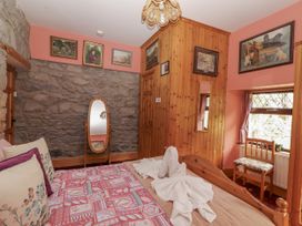 A bedroom with a bed and a mirror at Coole Gate Lodge, Gort, County Galway