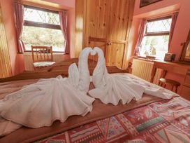A bedroom with towel swans on a bed at Coole Gate Lodge, Gort, County Galway