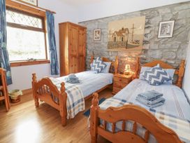 A bedroom with two single beds and a bedside table at Coole Gate Lodge, Gort, County Galway