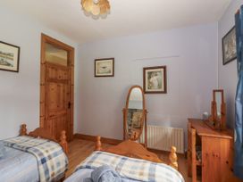 A bedroom with two beds and a mirror at Coole Gate Lodge in Gort, County Galway