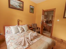 A bedroom with a bed and a chair at Coole Gate Lodge Gort, County Galway